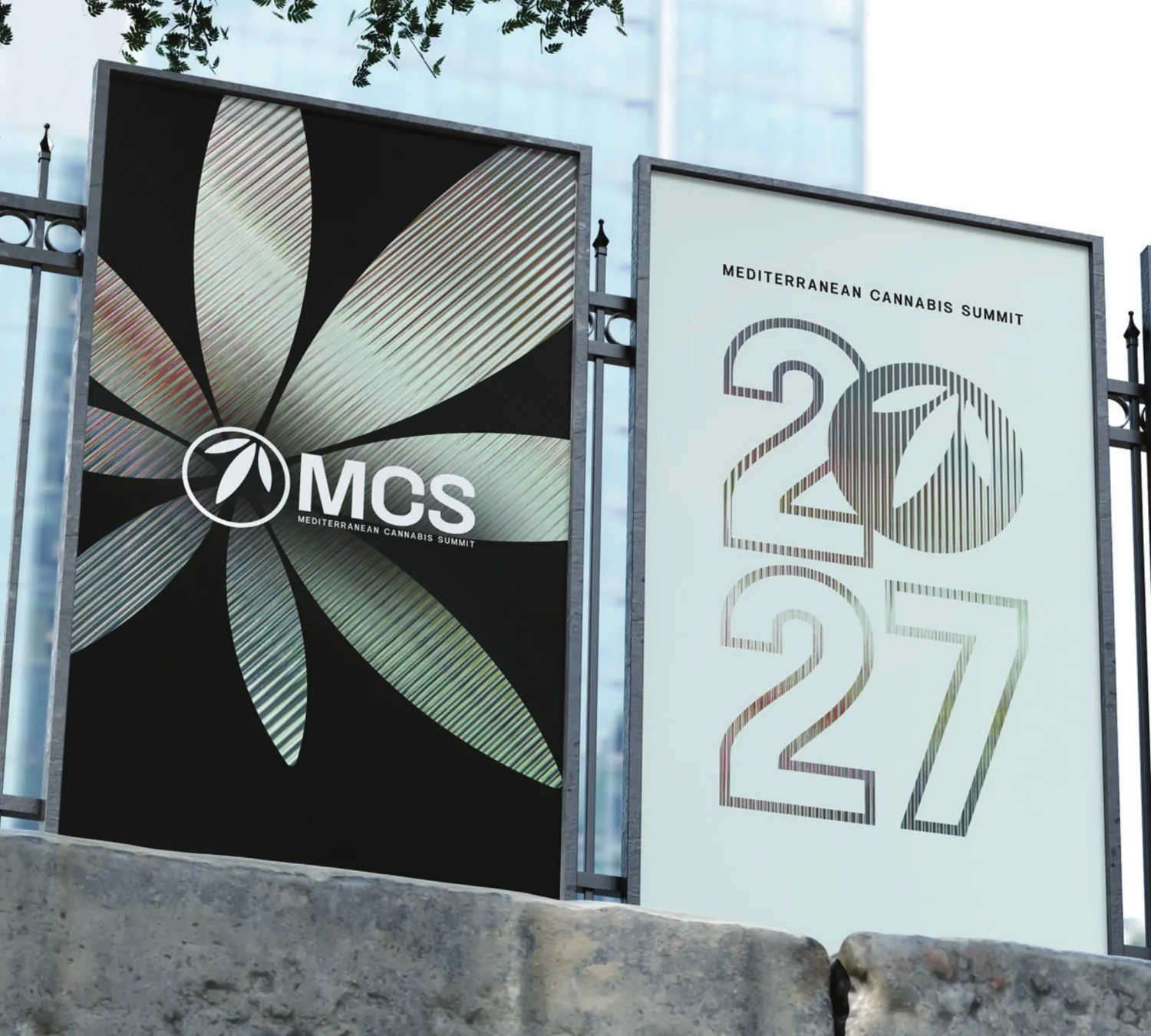 Two MCS 2027 posters mounted on street billboards, one carrying the summit mark and one the 2027 lockup